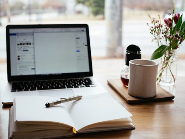 Laptop and cup with an open book