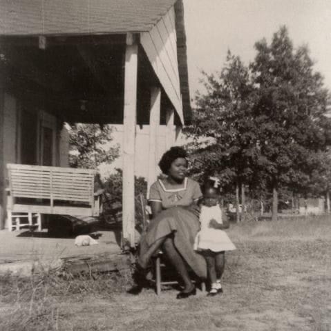 Young Oprah with her grandmother on the Mississippi farm, wearing handmade dresses and a hopeful smile